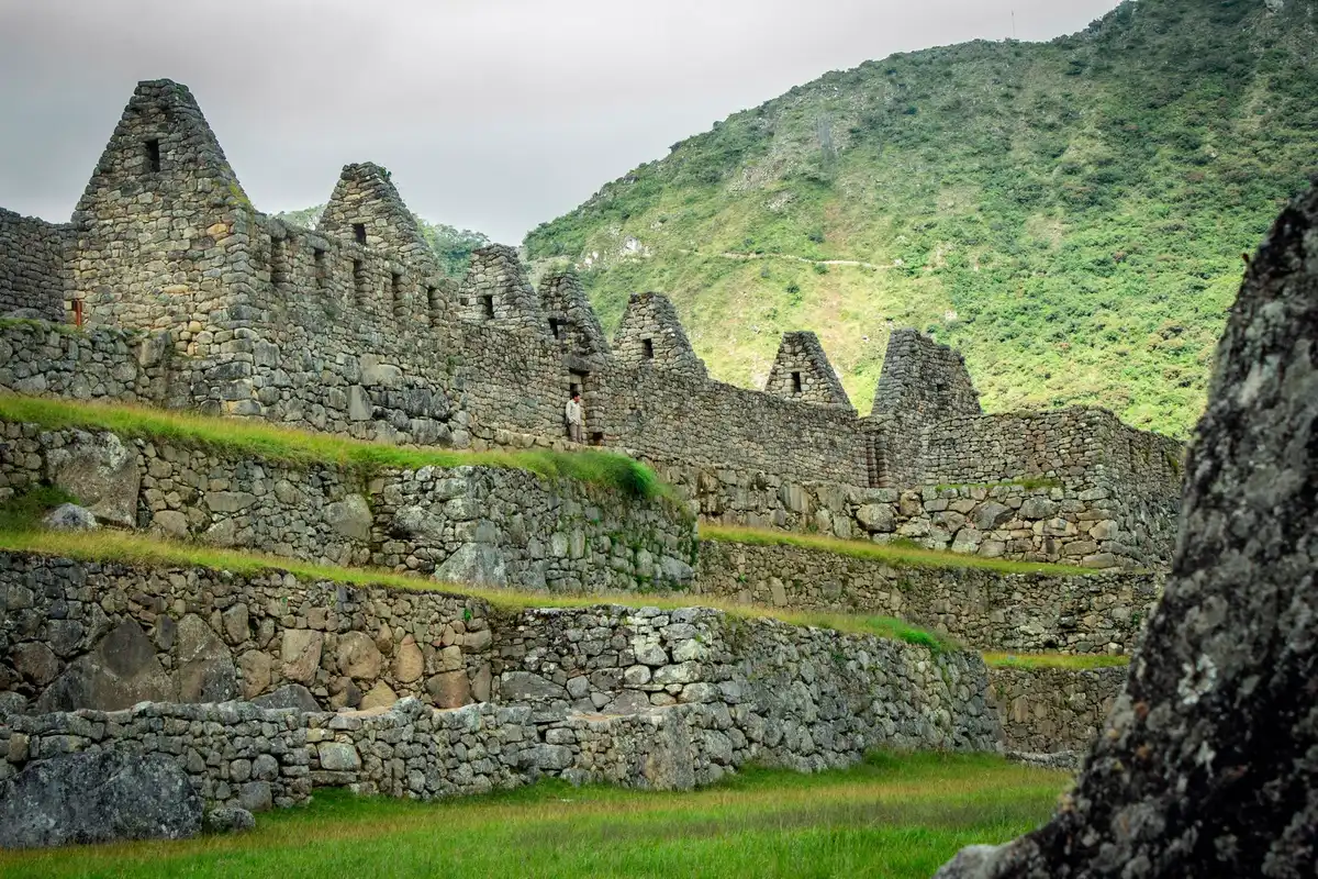 Vue aérienne du site archéologique de Machu Picchu avec visiteurs sur les ruines.