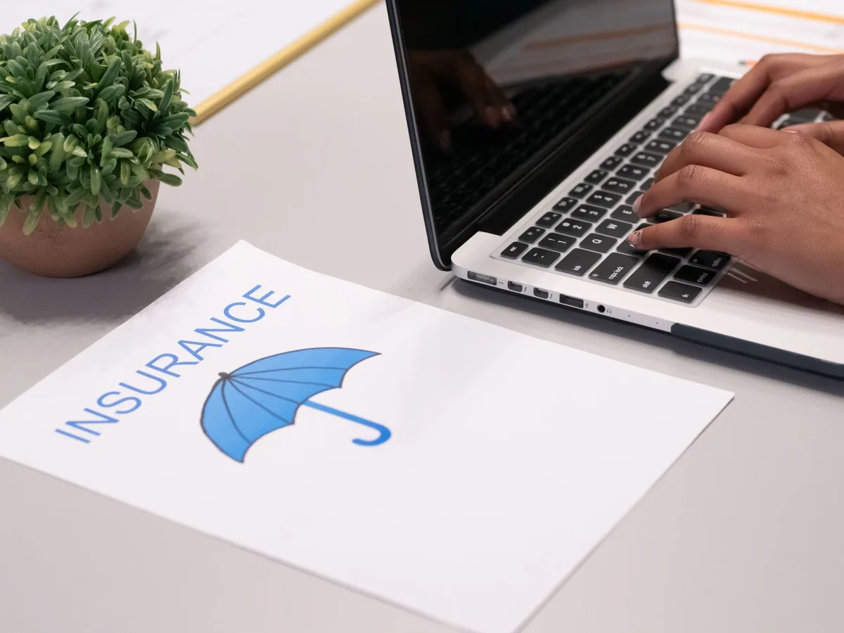 Documents d'assurance voyage et formulaires de couverture étalés sur un bureau