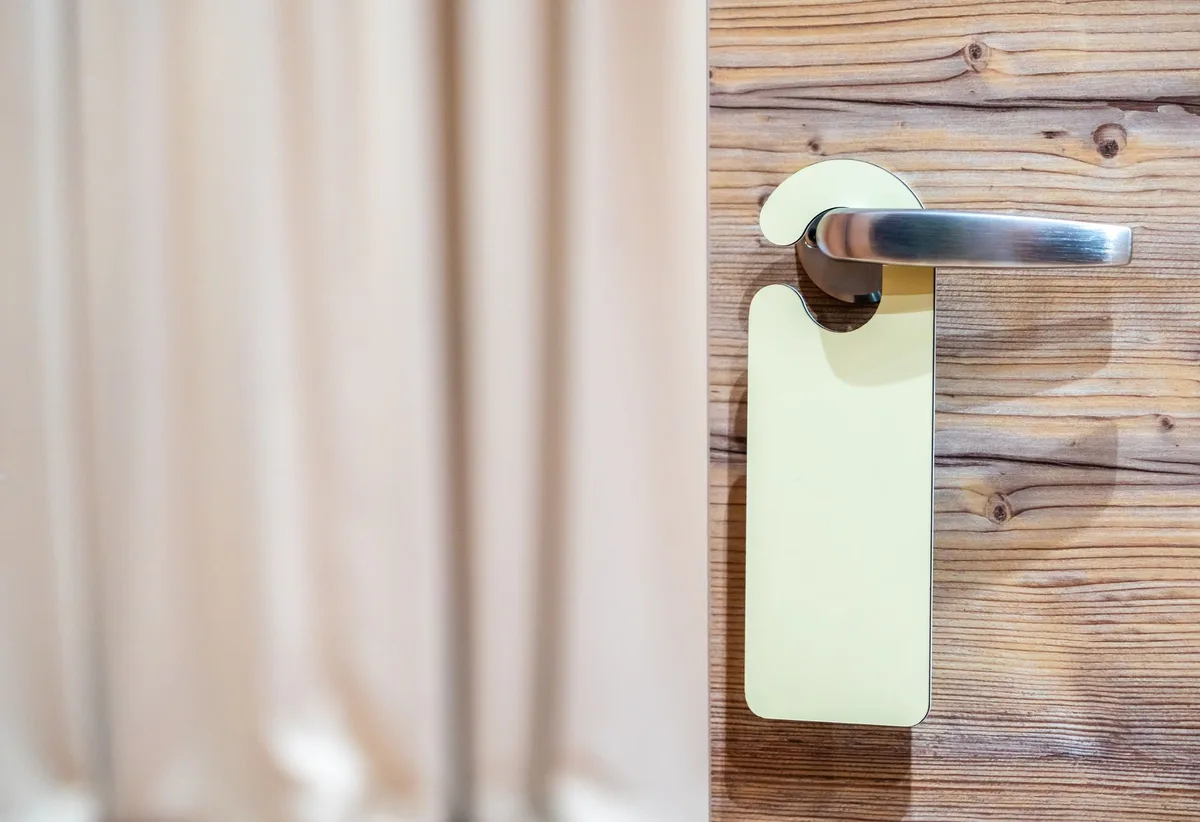 Pancarte « ne pas déranger » accrochée à la poignée d'une porte de chambre d'hôtel