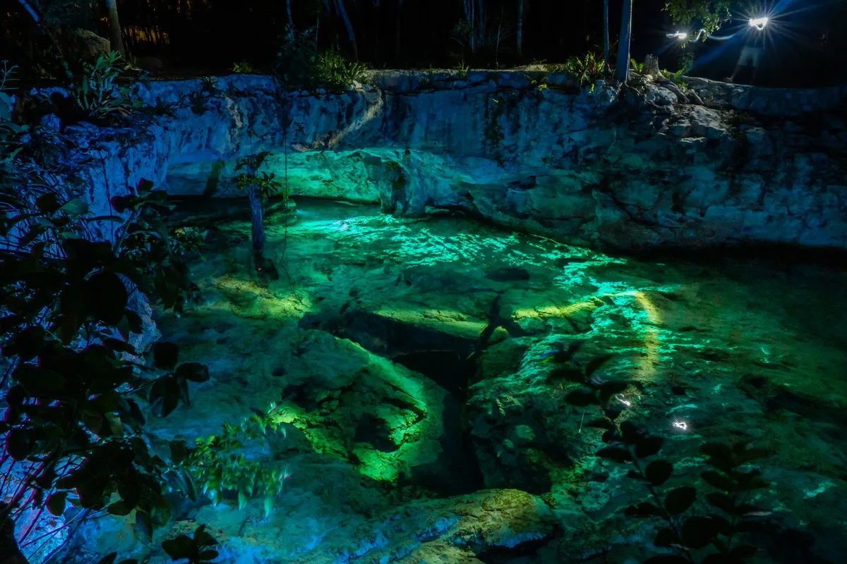 Baignade dans un cenote souterrain avec eau cristalline et formations rocheuses calcaires