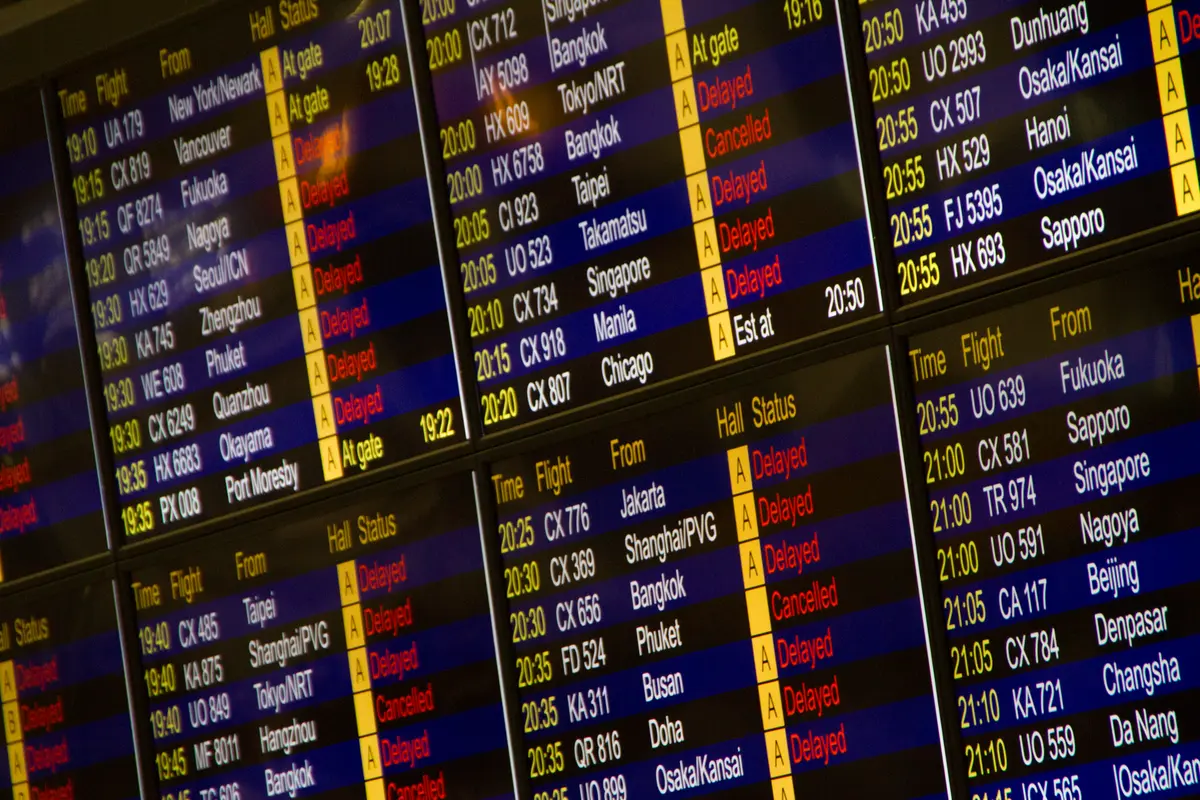 Panneau d'affichage des vols à l'aéroport montrant plusieurs itinéraires et horaires.