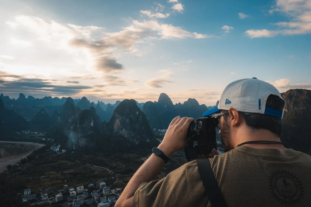 Photographe capturant un paysage local avec appareil photo en voyage