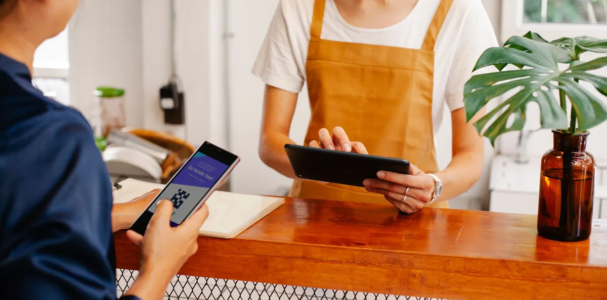Petit commerçant cambodgien acceptant un paiement numérique sur téléphone mobile