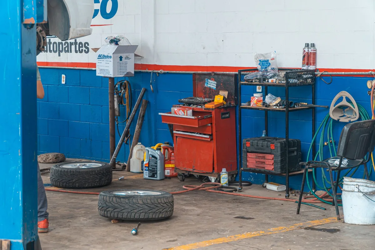 Coffre de voiture ouvert montrant roue de secours, cric et outils de changement