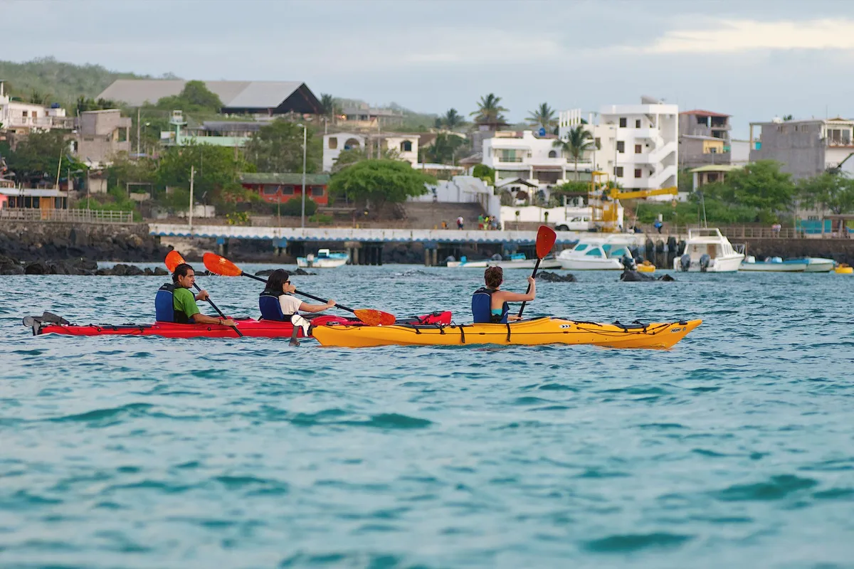 Voyageurs en kayak et snorkeling aux Galápagos observant la faune marine et les formations rocheuses