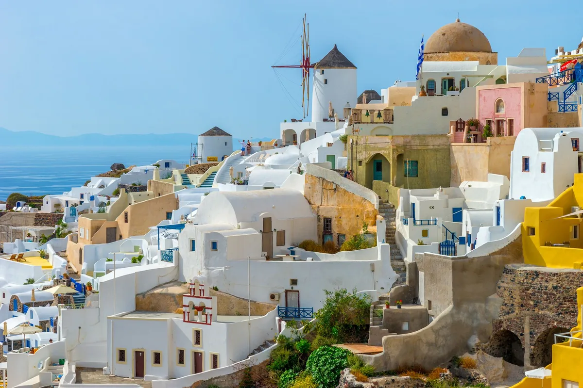 Maisons blanches aux dômes bleus surplombant les falaises de Santorin