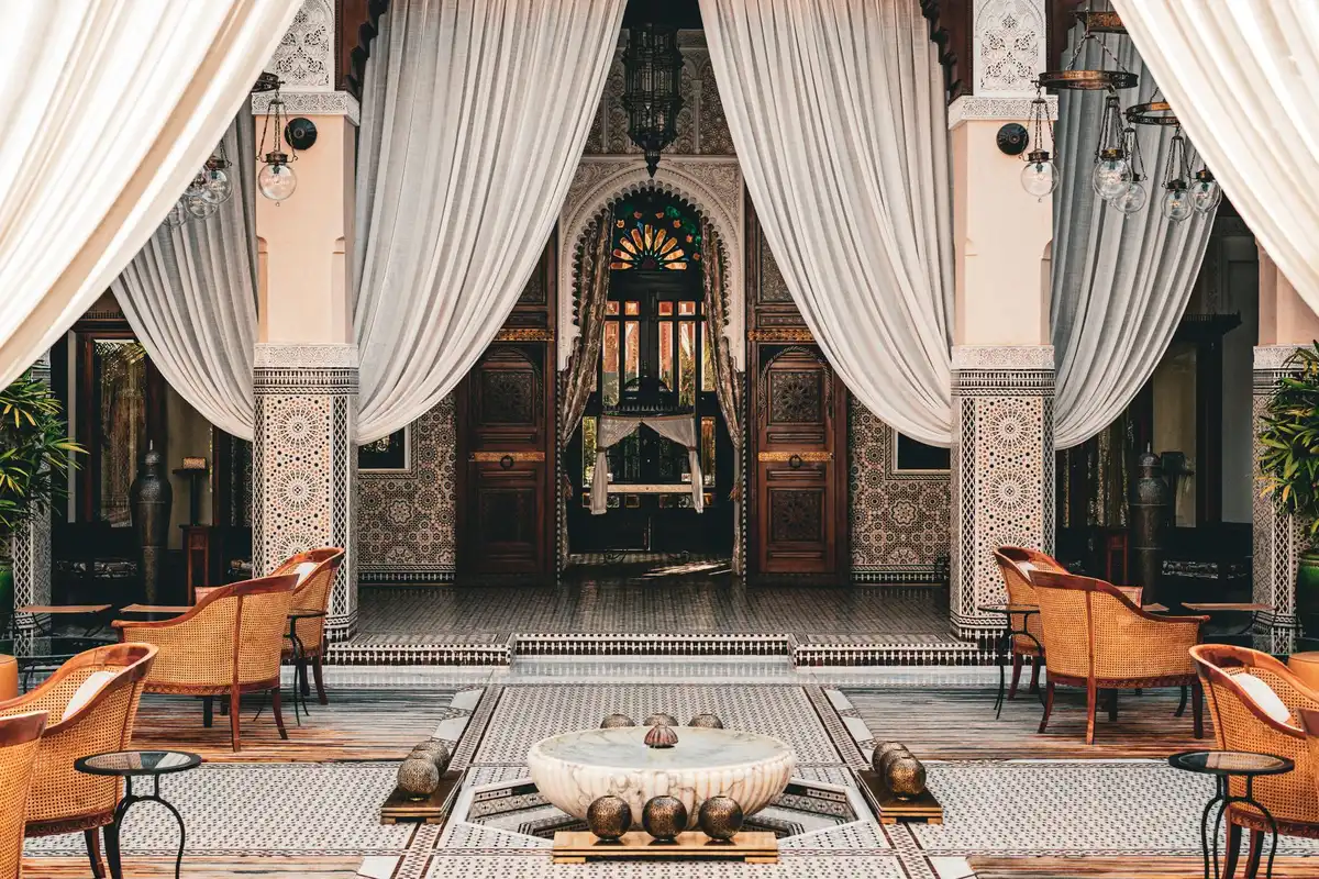 Patio intérieur d'un riad traditionnel avec carrelage et plantes en pots.
