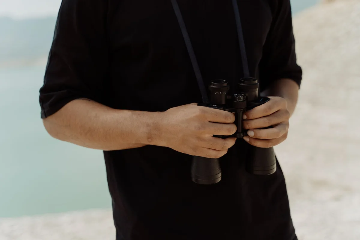 Guide de safari observant la faune avec des jumelles depuis un véhicule