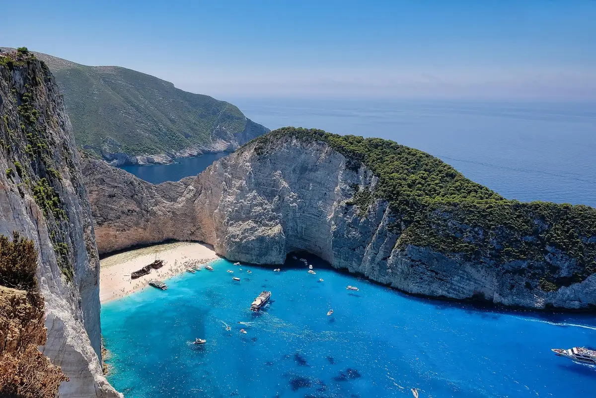 Crique méditerranéenne aux eaux turquoise avec falaises calcaires et végétation côtière