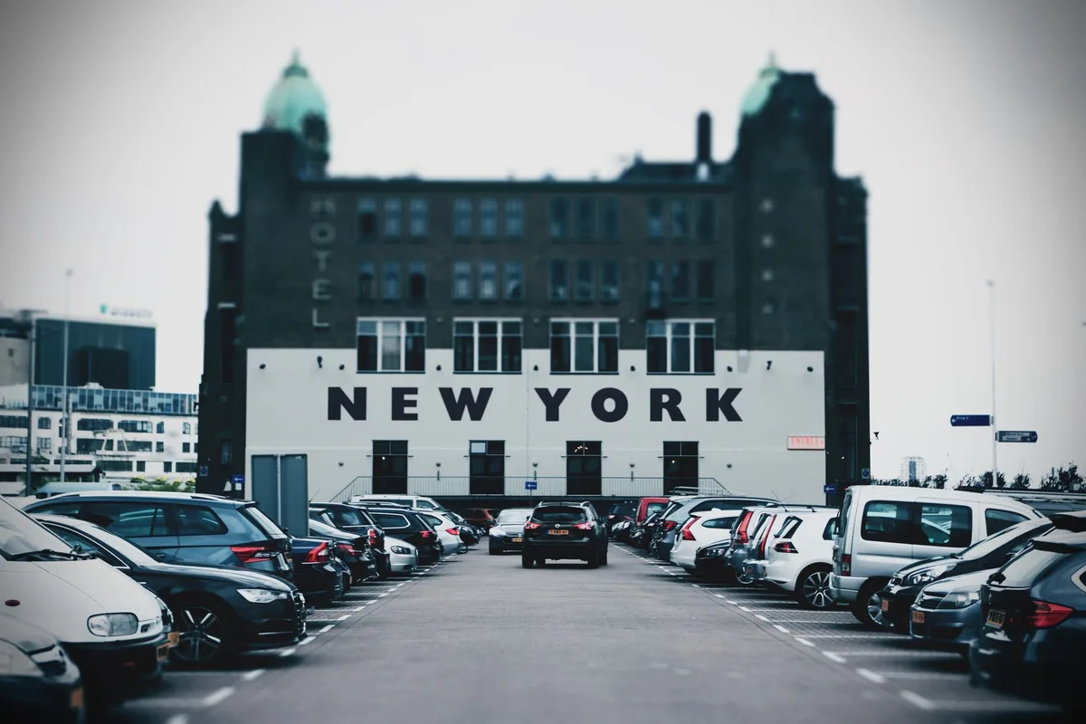Parking d'hôtel avec voitures et zone urbaine en arrière-plan