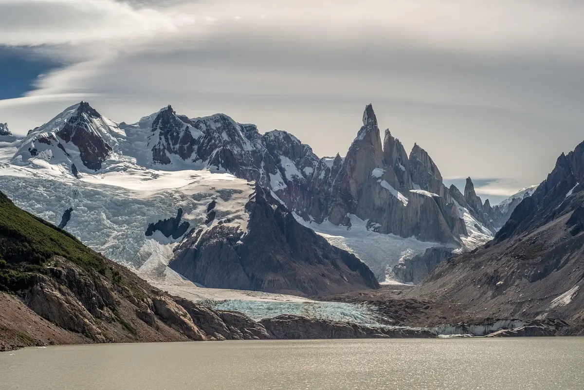 Randonneurs marchant dans un paysage montagneux de Patagonie avec pics enneigés