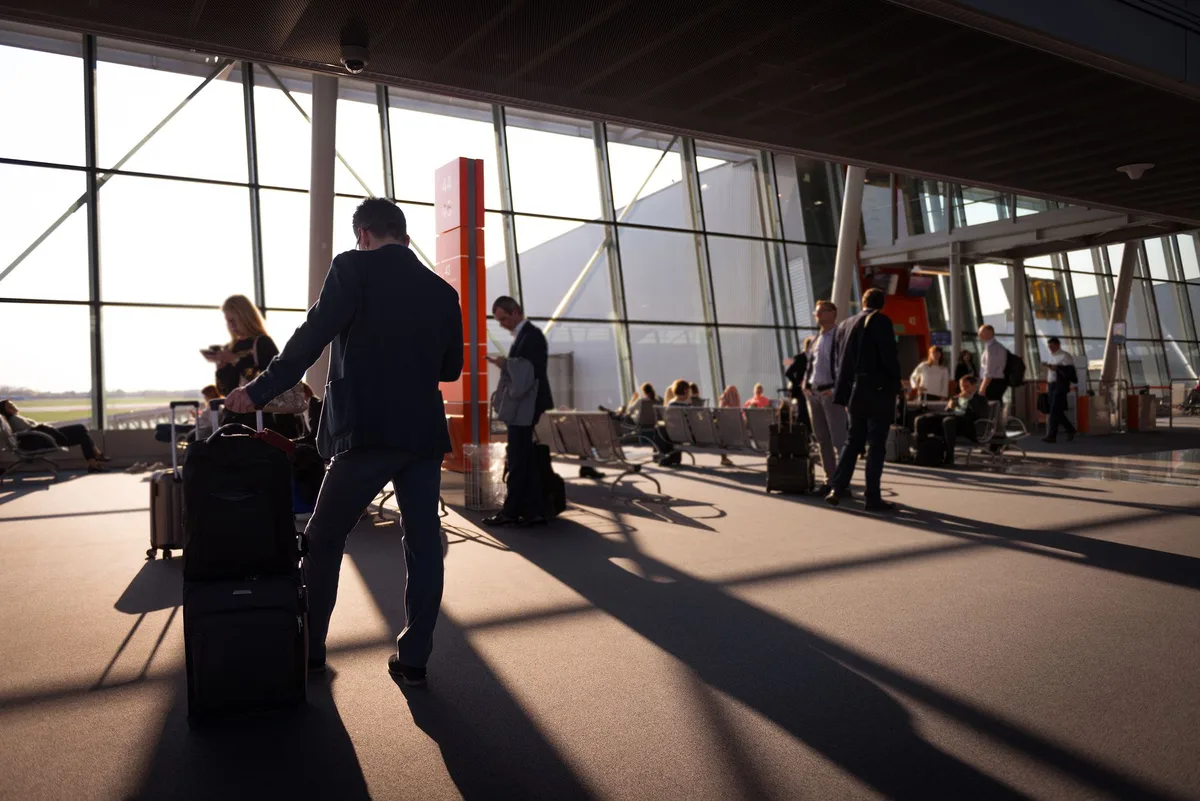 Voyageur léger avec bagage à main dans un terminal d'aéroport