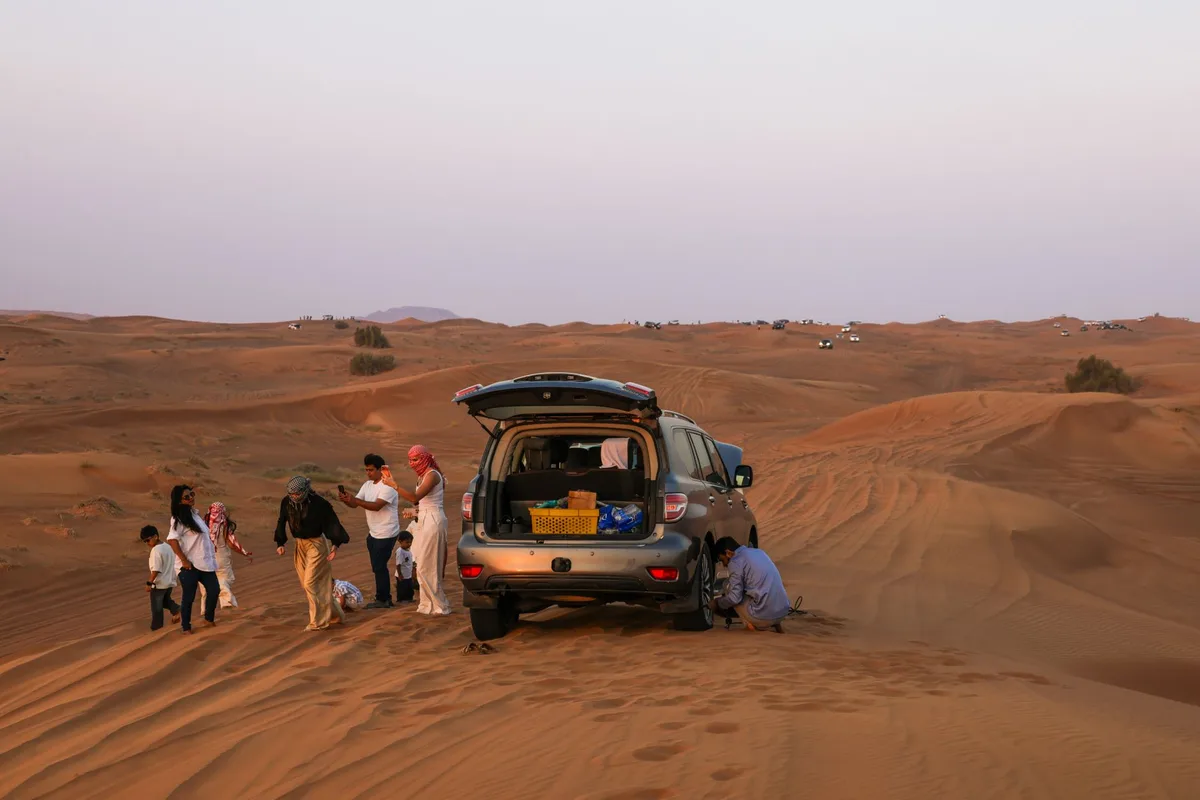 Véhicule 4x4 traversant les dunes du désert égyptien avec coucher de soleil doré à l'horizon