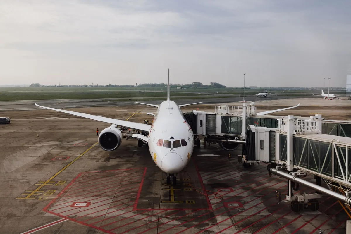 Aéroport fermé avec panneaux d'information et voyageurs attendant des annonces