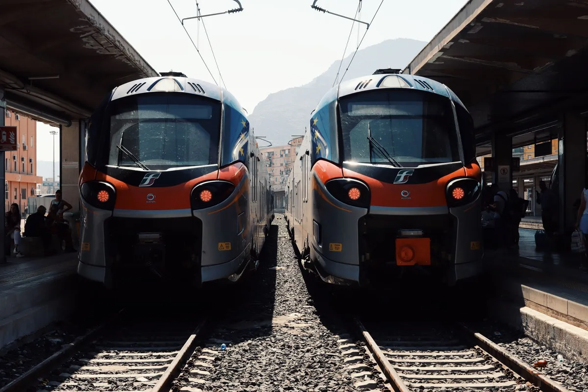 Quai de gare avec voyageurs attendant un train en Italie du Nord