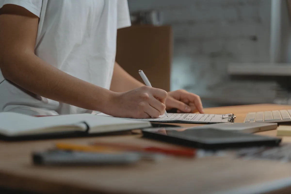 Feuille de checklist et plans disposés sur un bureau avec stylo et tablette