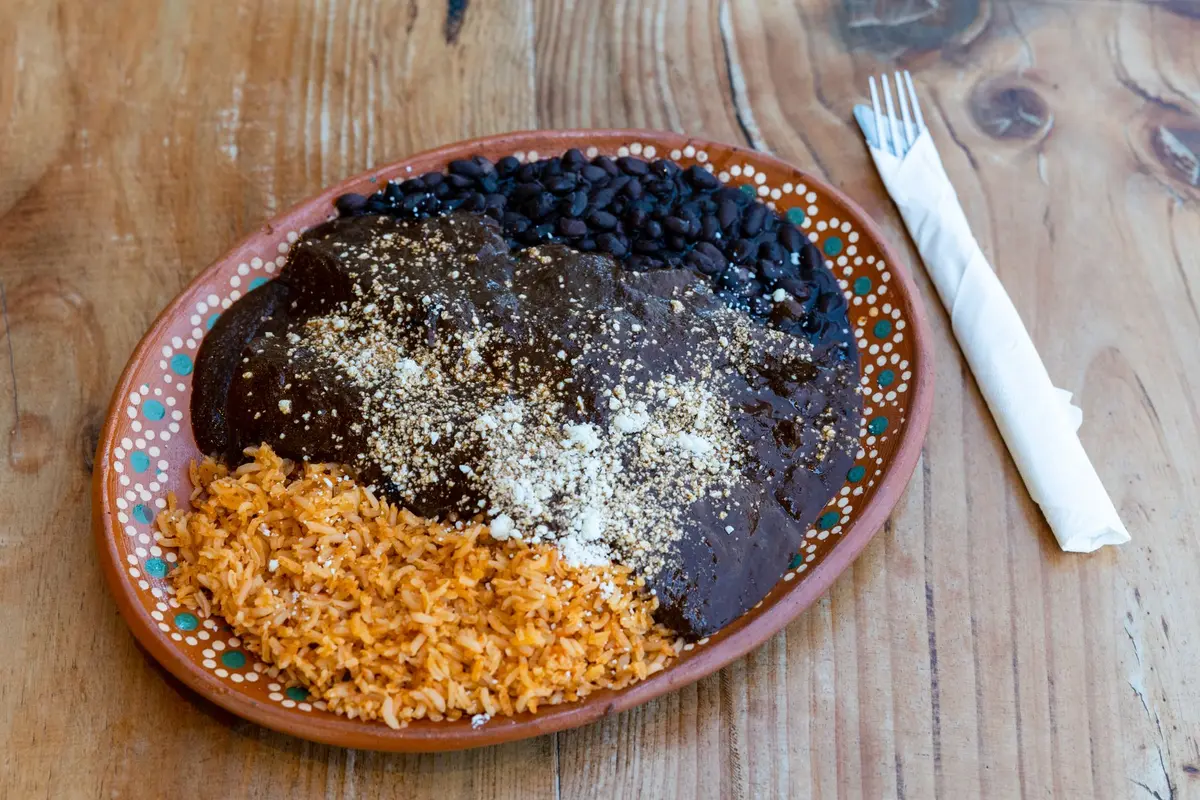 Mole poblano servi dans un bol blanc, sauce riche et complexe avec volaille