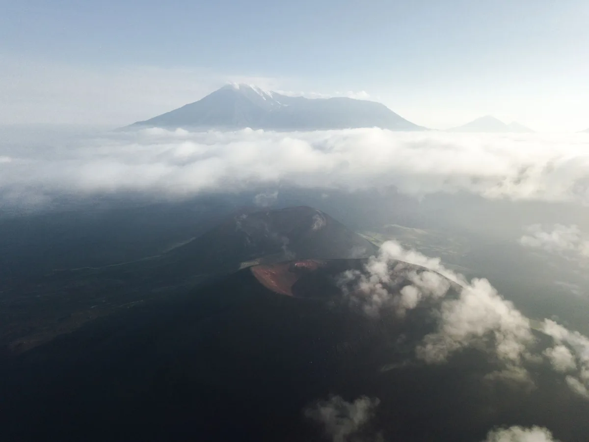 Vue panoramique d'un cratère volcanique entouré de forêts d'altitude et de zones humides