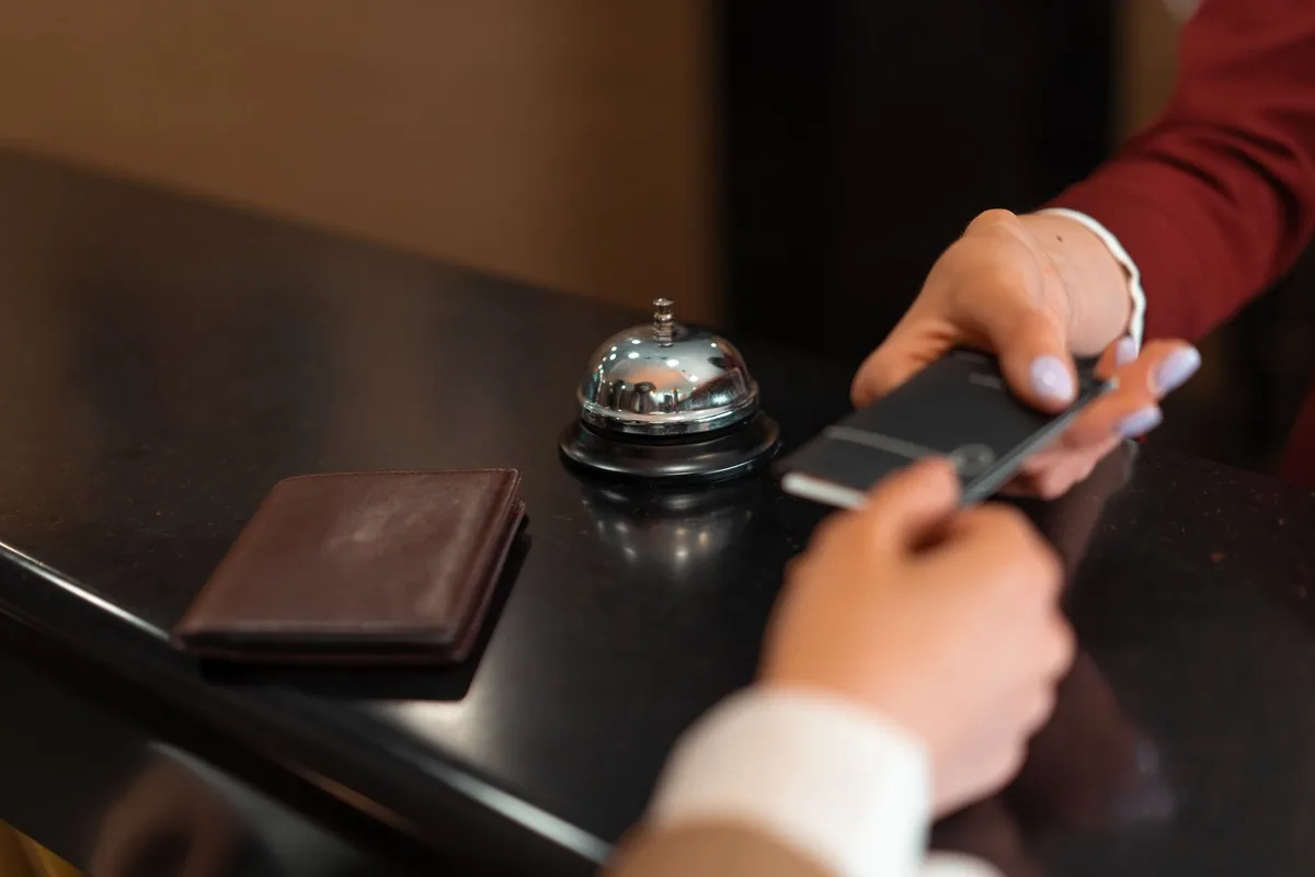 Personnel d'hôtel utilisant une interface sans-contact pour accueillir les clients.