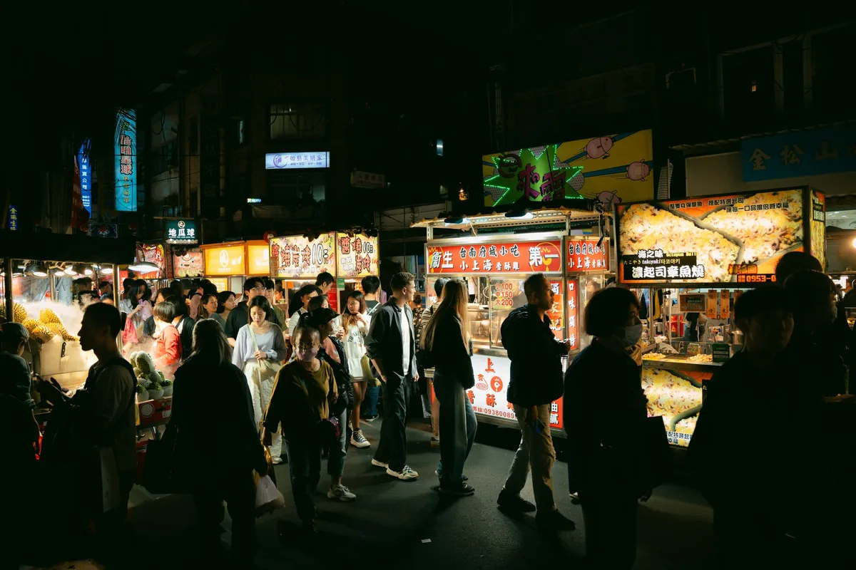 Vendeurs préparant des plats dans un marché de street food animé