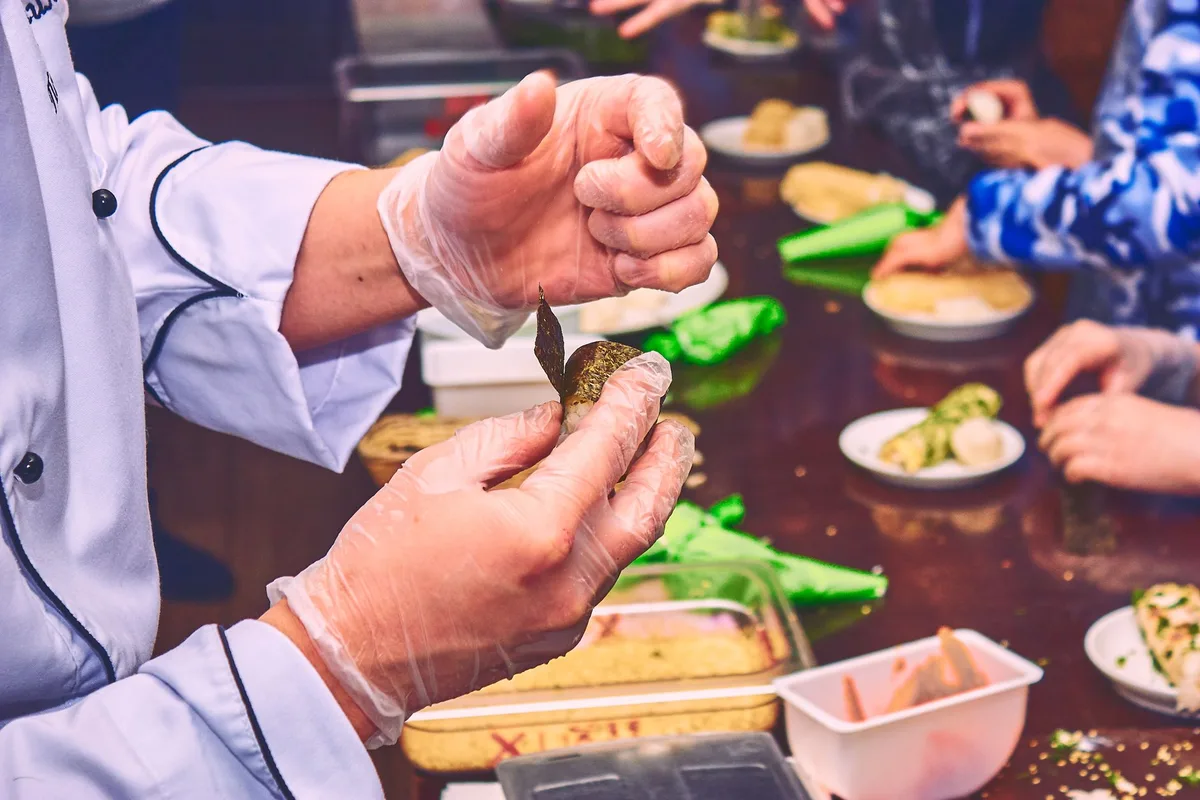 Guide culinaire local montrant des techniques de préparation à des touristes