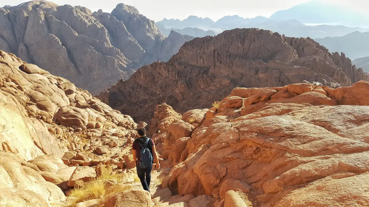 Randonneurs sur un sentier en altitude avec vue sur les montagnes désertiques de l'Arizona.