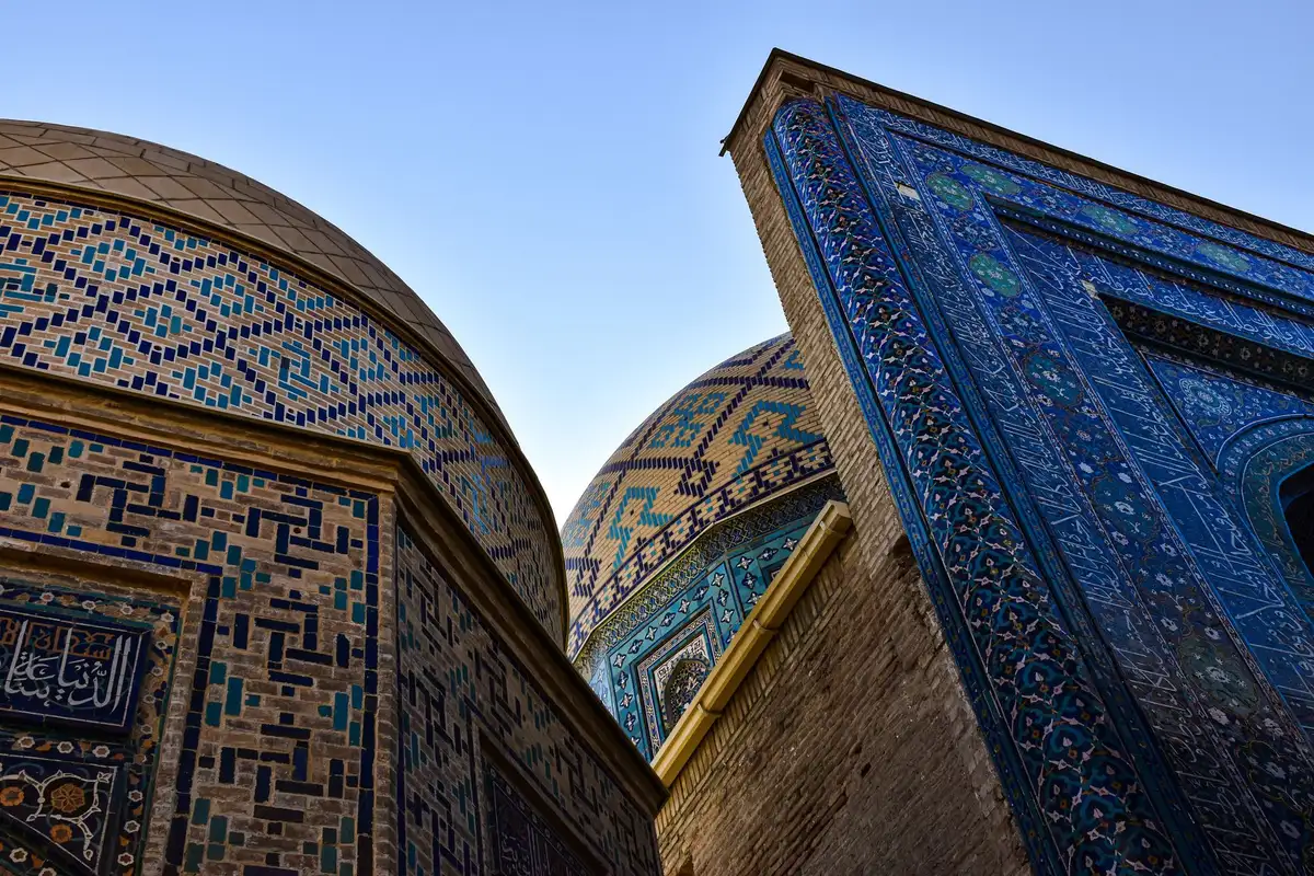Façades architecturales bleues et dorées de Samarcande avec dômes et carrelages traditionnels.