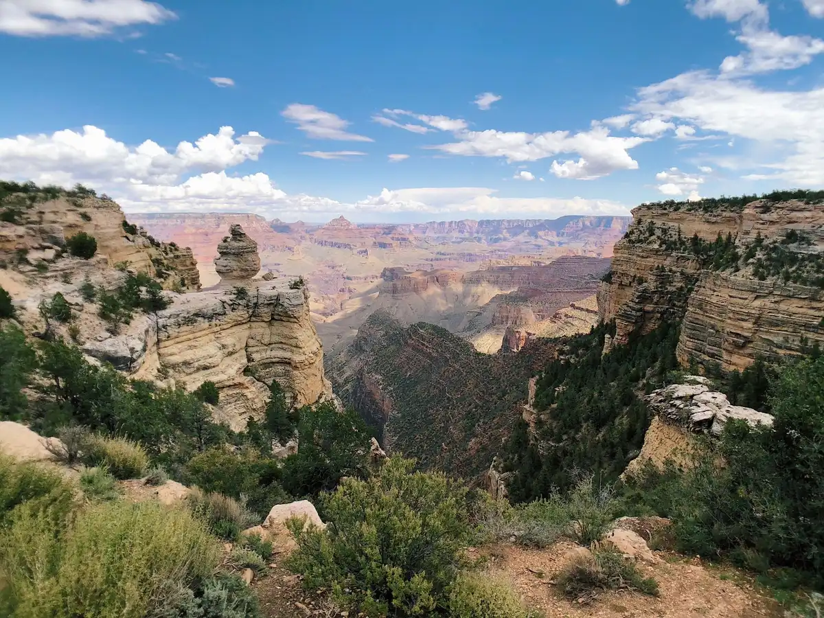 Vue spectaculaire d'un canyon avec formations rocheuses colorées et ciel bleu