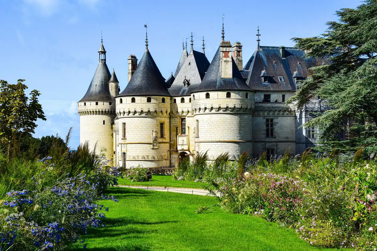 Vue aérienne d'un château avec ses jardins à la française, entouré de verdure