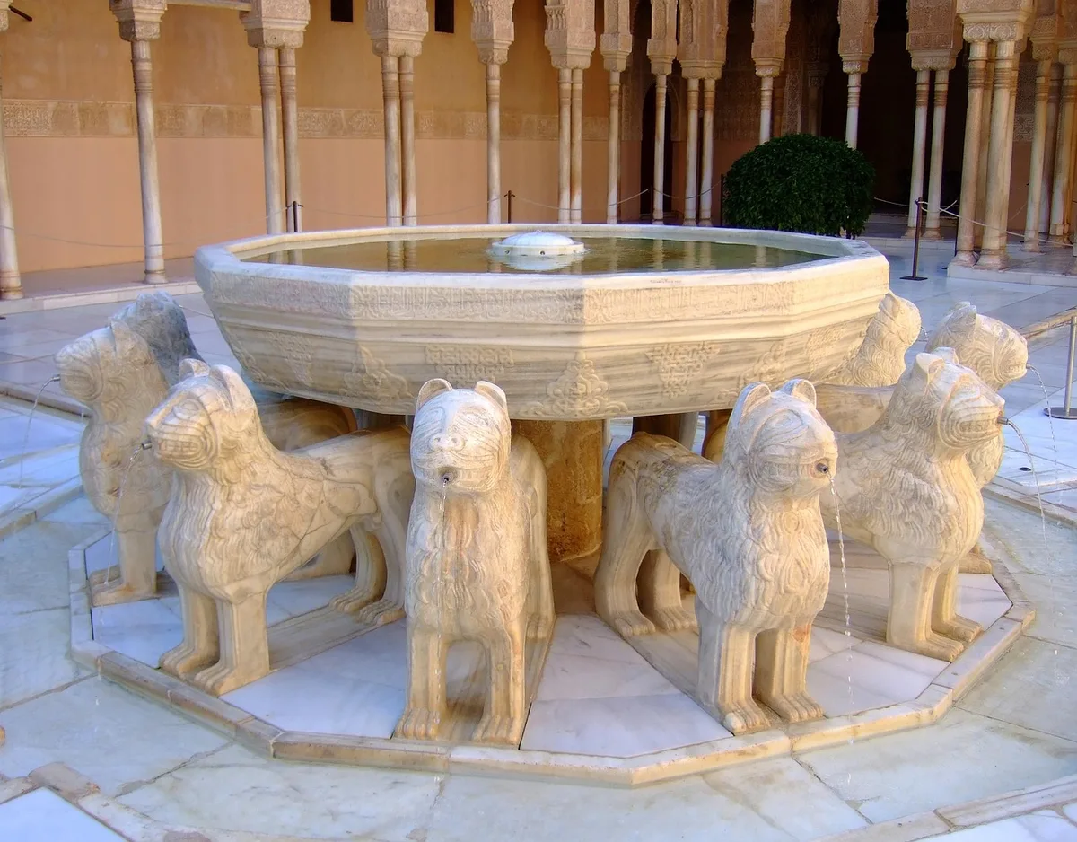 Cour intérieure avec fontaines et jardins ensoleillés rappelant l'Alhambra