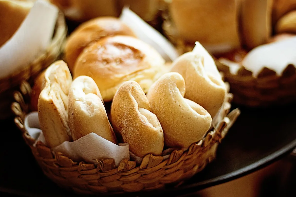 Panier de pique-nique garni de pain rustique, fromages et produits locaux