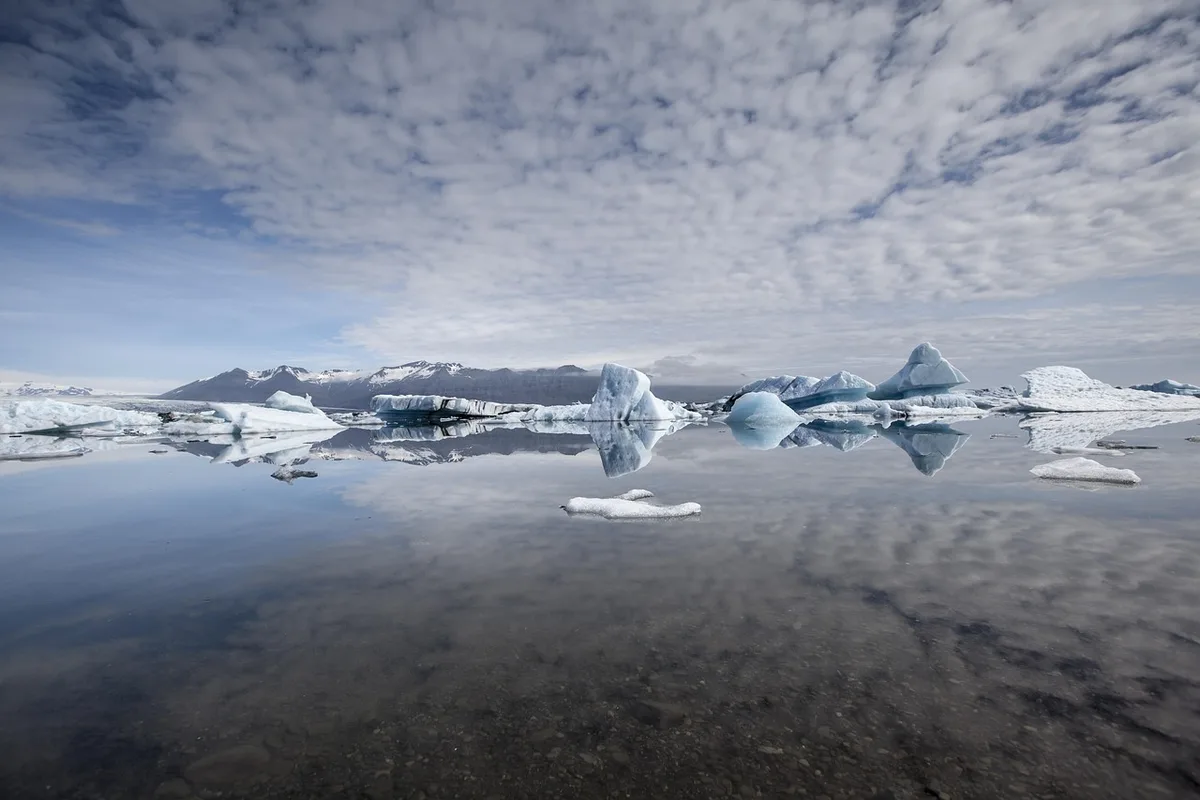 Lagon glaciaire avec icebergs flottants et montagnes en arrière-plan