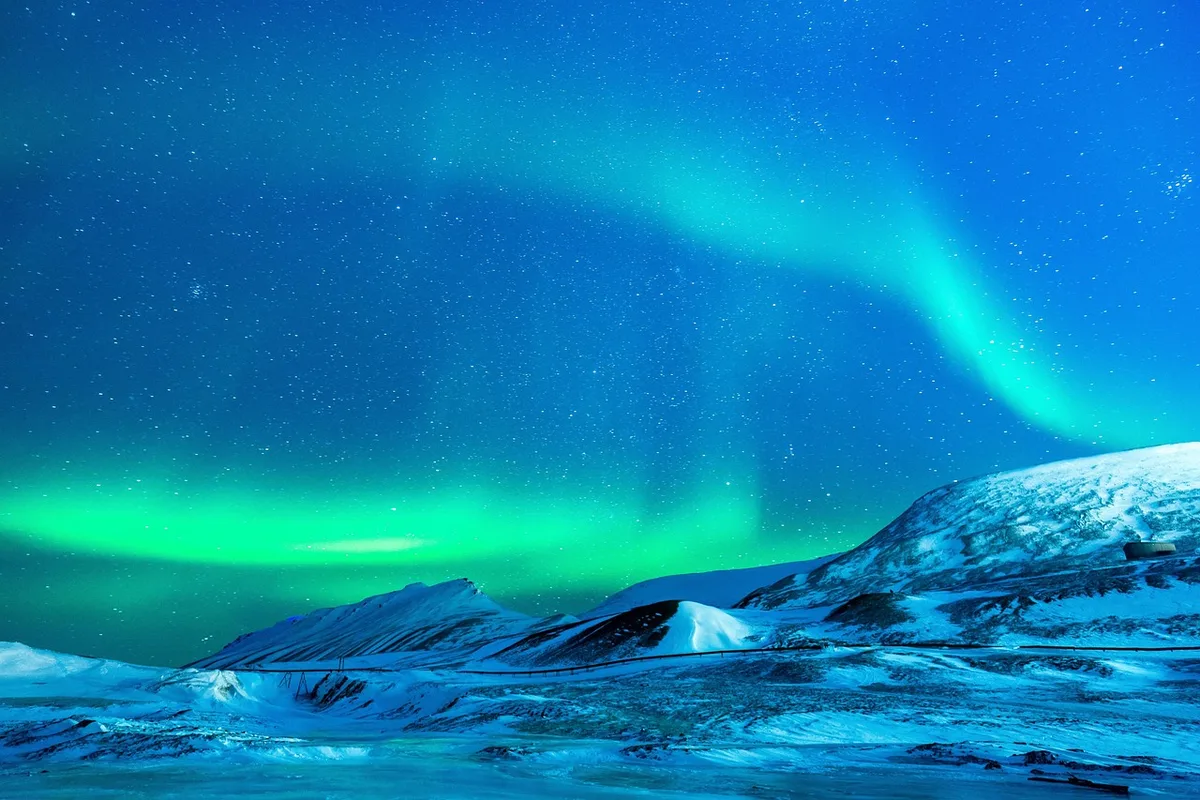 Paysage hivernal enneigé avec possibilité d'aurores boréales dans le ciel nocturne