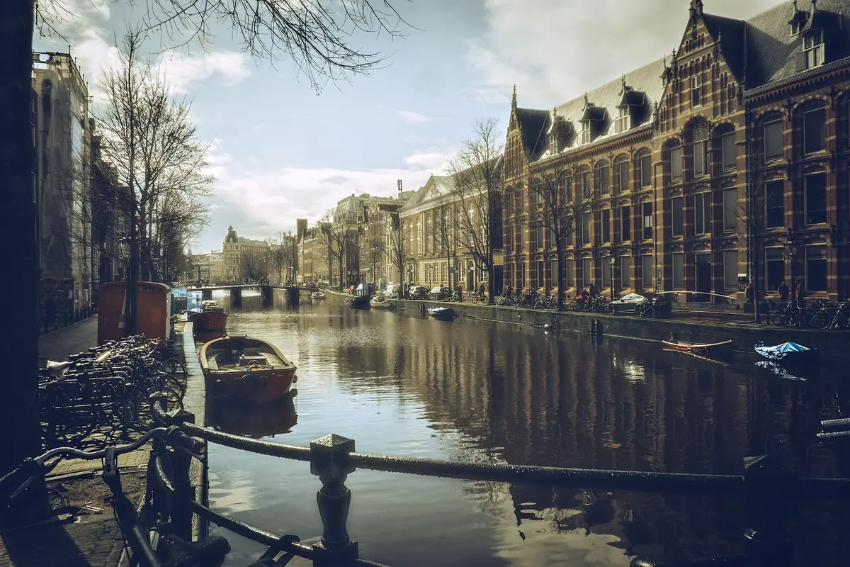 Vue diurne d'un quai d'Amsterdam avec passagers anonymes et bateaux