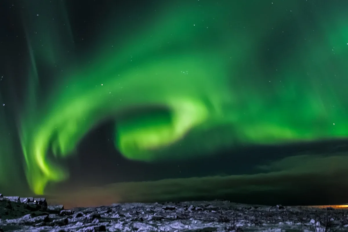 Aurores boréales au‑dessus d'un paysage islandais enneigé
