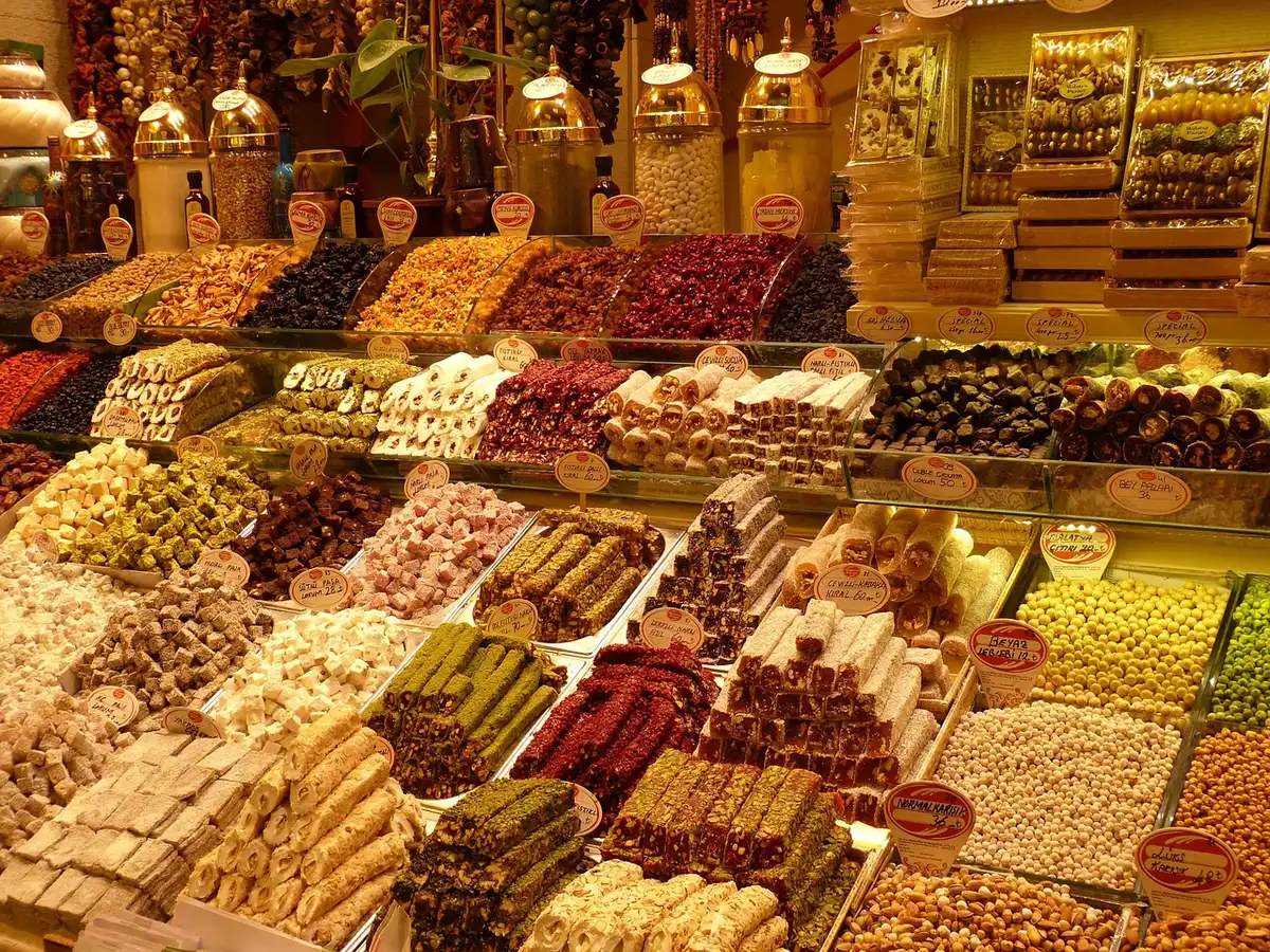 Allée intérieure d'un marché couvert avec étals de produits et visiteurs