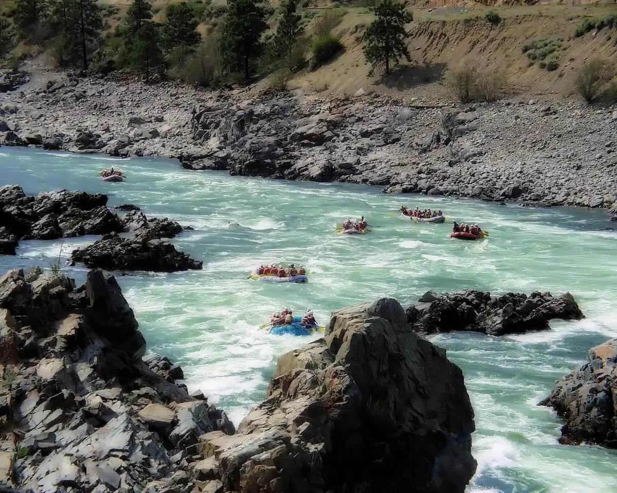 Groupe en raft sur des rapides, guides et gilets de sauvetage visibles