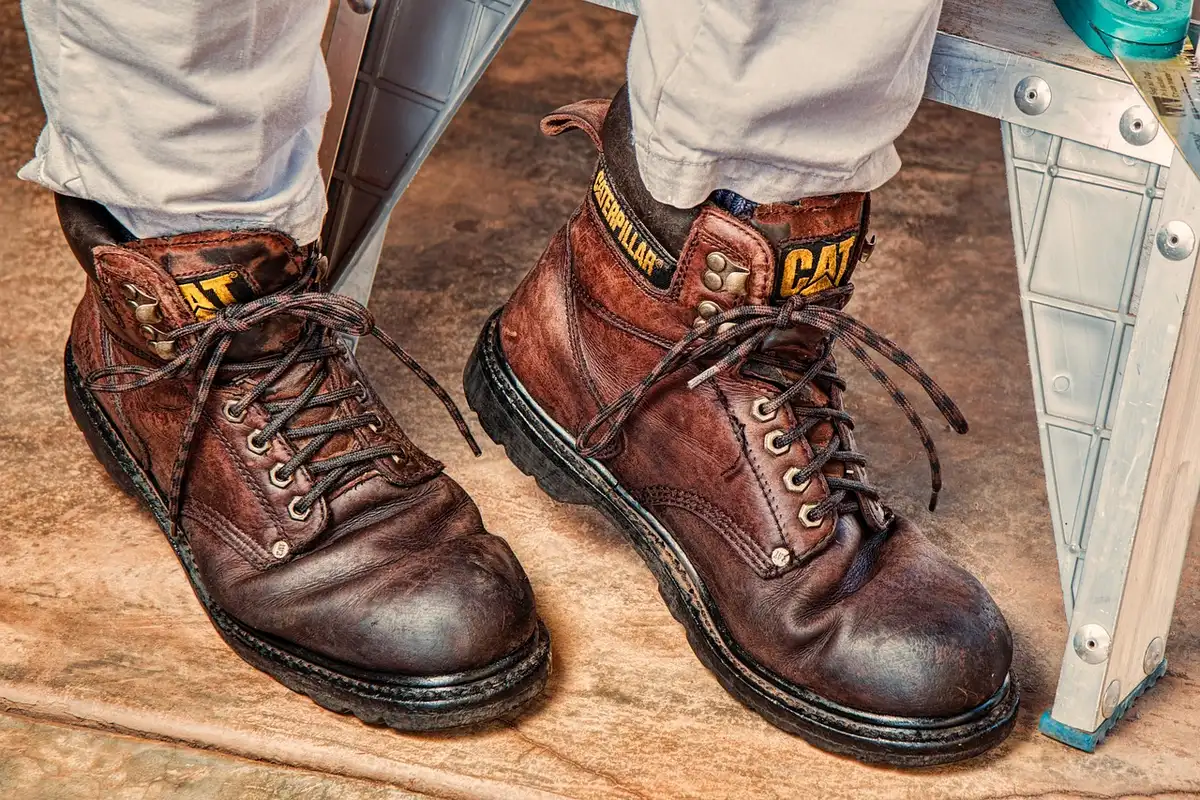 Chaussures de randonnée, sac à dos et carte posés sur une roche