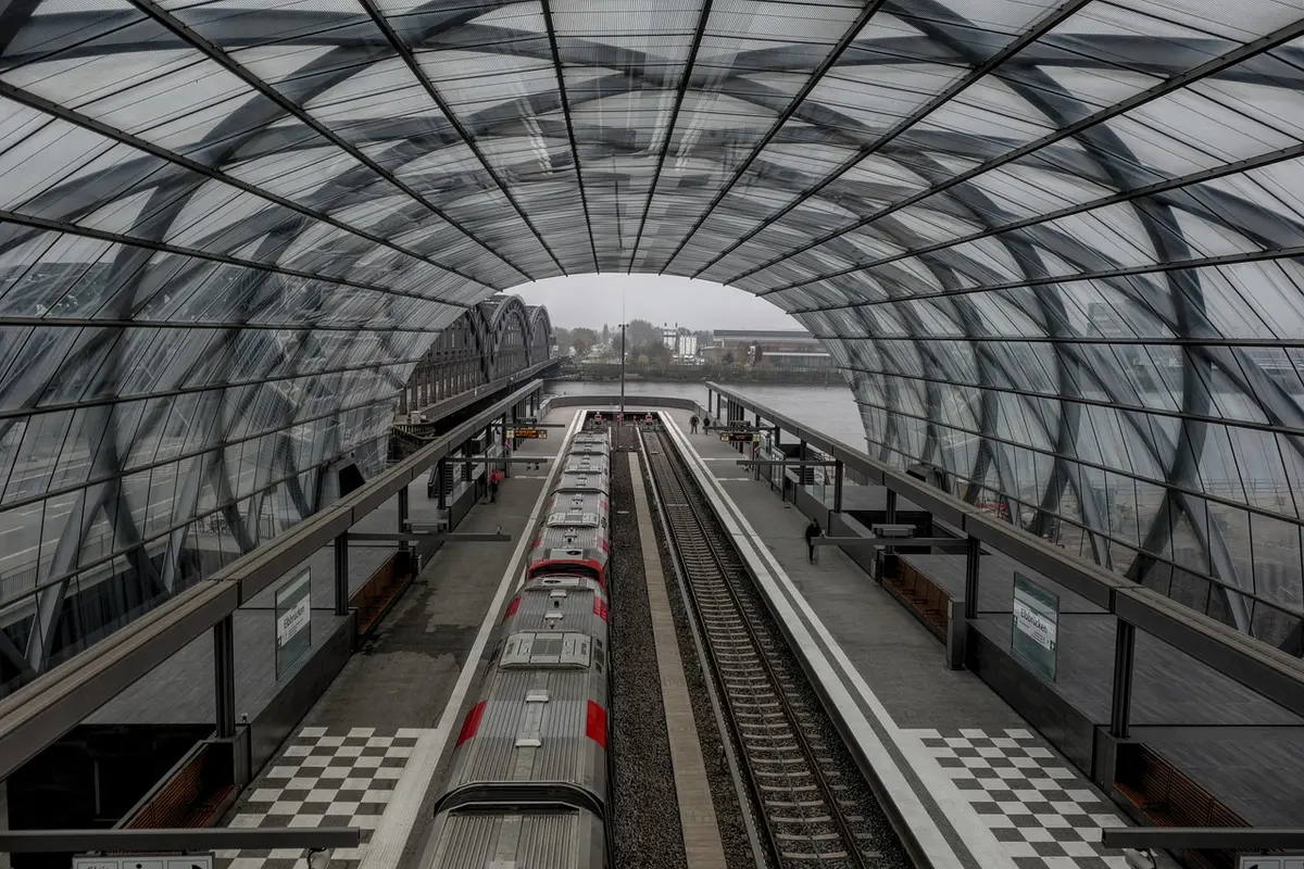 Panneau d'horaires et quai de gare illustrant les temps de trajet