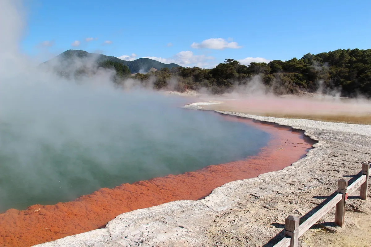 Bassins extérieurs de sources thermales avec vapeur légère et montagne en arrière-plan