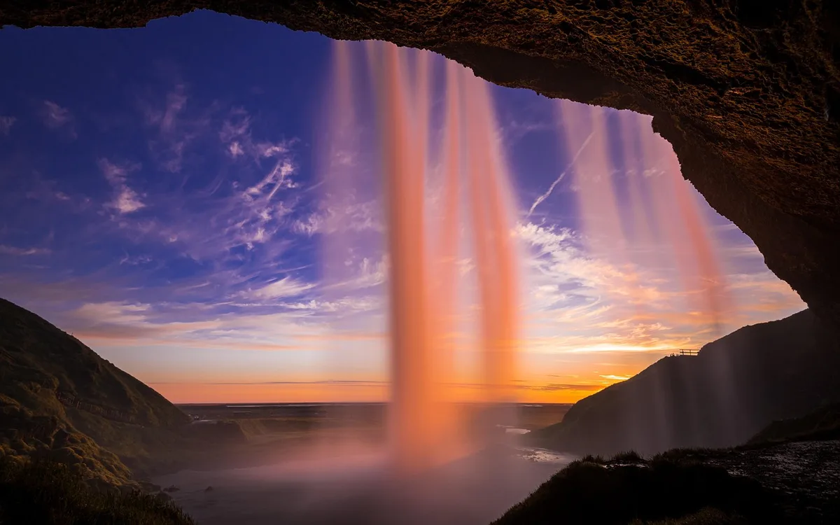 Cascade se jetant près de la côte avec mer et falaises visibles