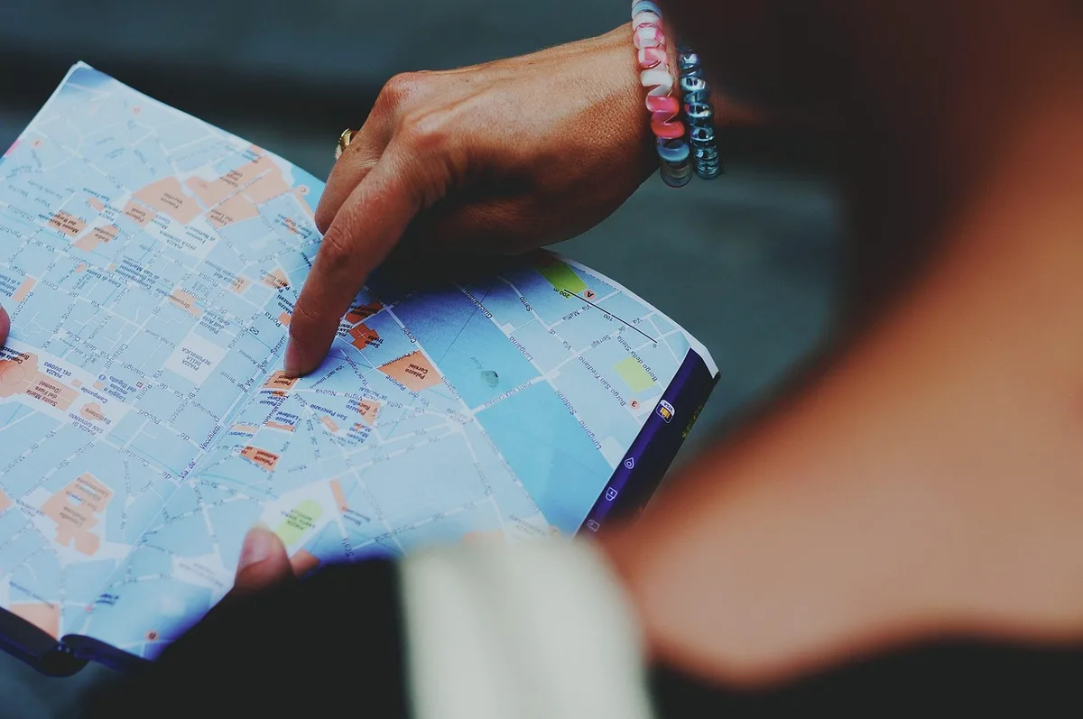 Carte et billet de train posés sur une table avec une petite valise