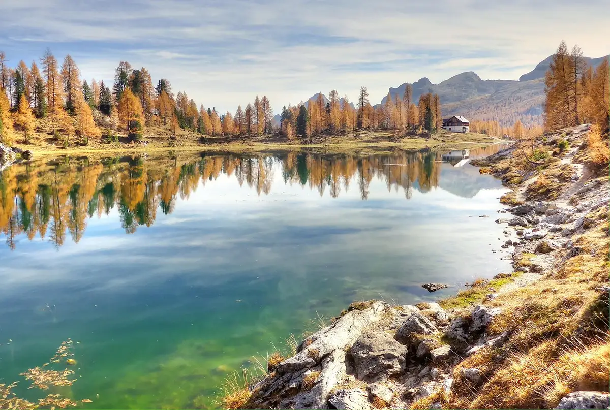 Vue d'un lac alpin turquoise en été avec falaises et prairies