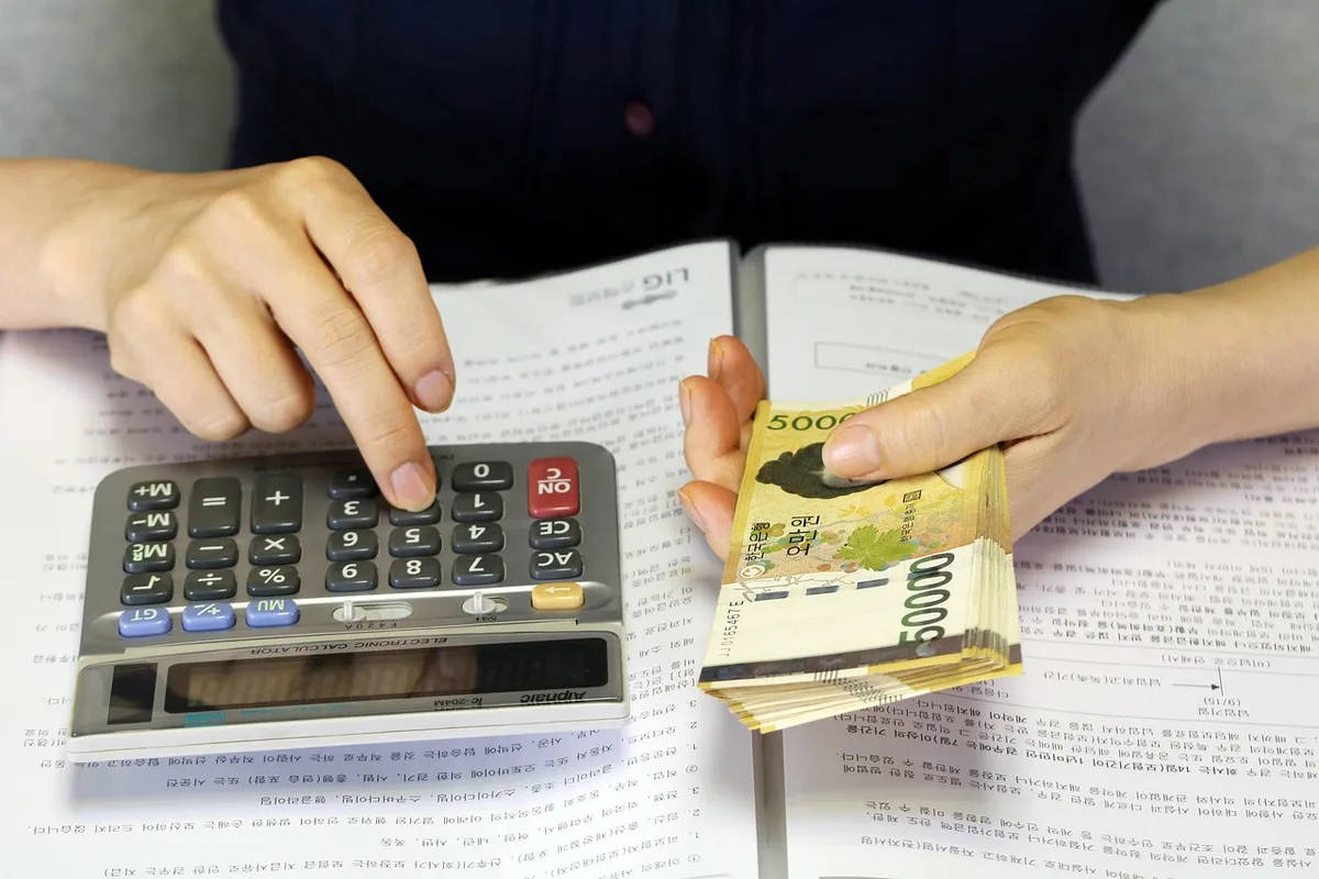 Calculatrice, billets et notes pour établir le budget du voyage