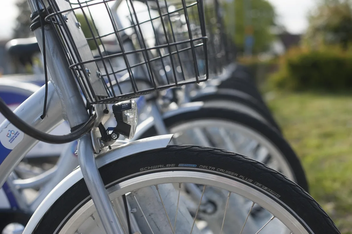 Personnes avec vélos à la location près d’une place ensoleillée